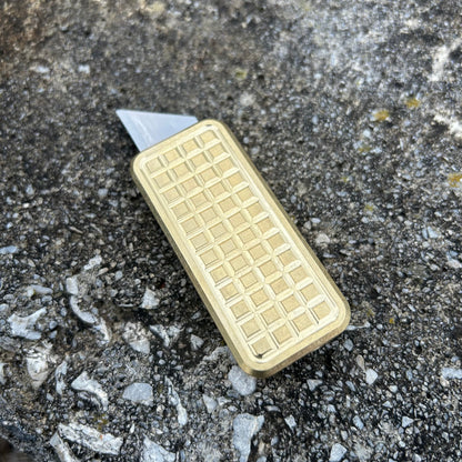 Brass Zero v2 in a grenade milling pattern with a stone background