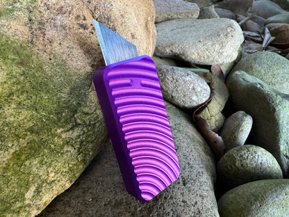 RiveryMFG Zero fidget utility knife in custom purple CadLab color with extended blade on stones