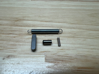 Zero knife big spring, small spring, key and pin on a wooden table