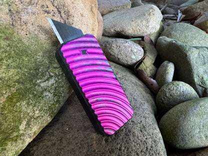 Pink and charcoal anodized RiveryMFG Zero retractable utility knife.